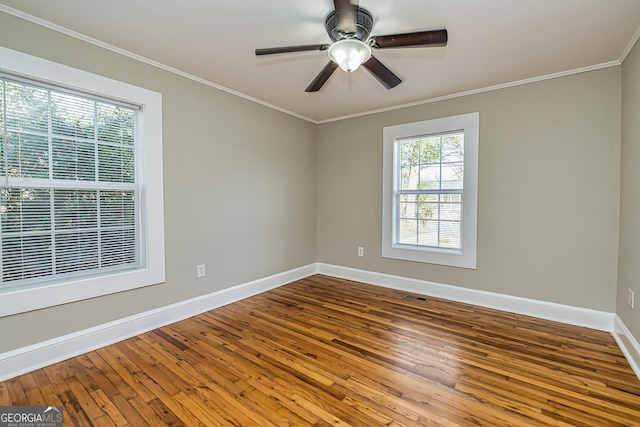 empty room featuring hardwood / wood-style flooring, crown molding, and ceiling fan