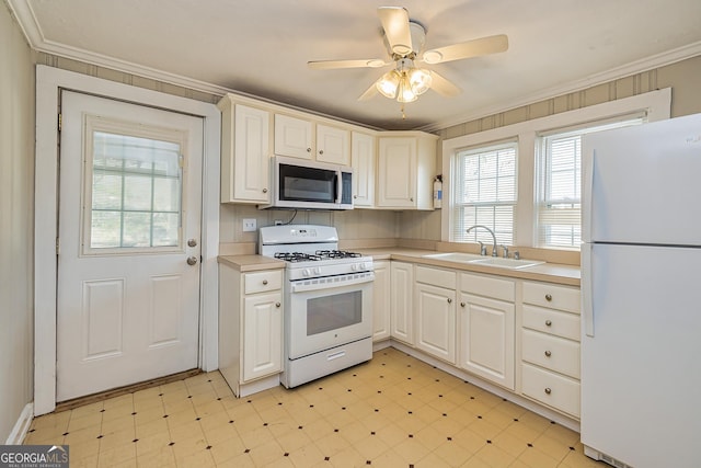 kitchen with white appliances, sink, ceiling fan, white cabinets, and ornamental molding