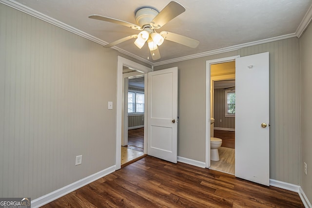 unfurnished bedroom with multiple windows, ornamental molding, dark wood-type flooring, and ceiling fan