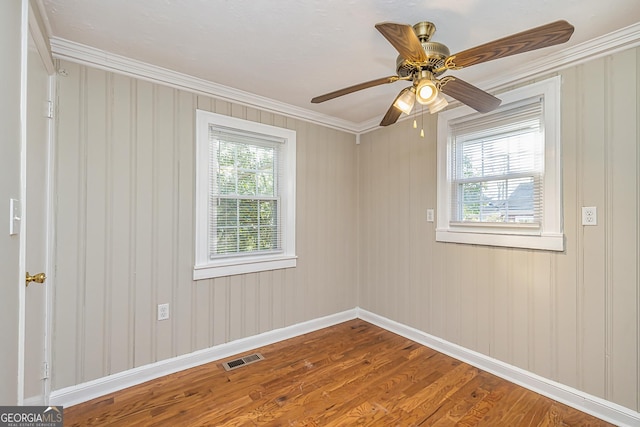 spare room with crown molding, ceiling fan, and wood-type flooring