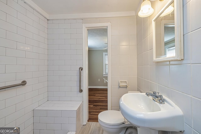 bathroom with sink, tile walls, toilet, hardwood / wood-style flooring, and ornamental molding