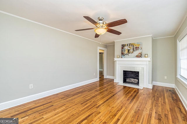 unfurnished living room with a fireplace, ornamental molding, hardwood / wood-style floors, and ceiling fan
