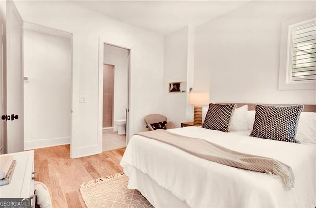 bedroom featuring ensuite bathroom and light hardwood / wood-style flooring