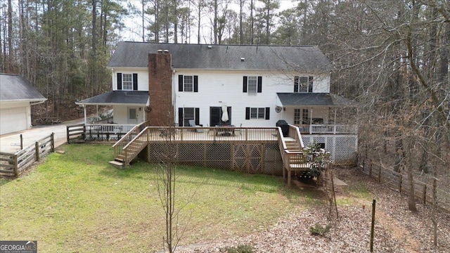 rear view of property featuring stairs, a deck, a lawn, and a chimney