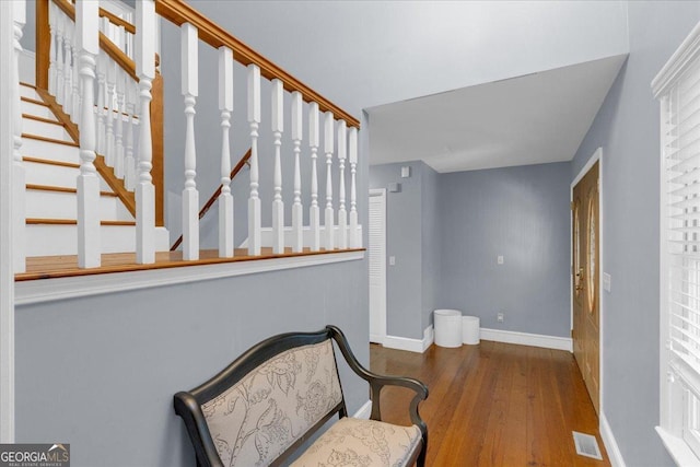 sitting room featuring stairway, wood finished floors, visible vents, and baseboards