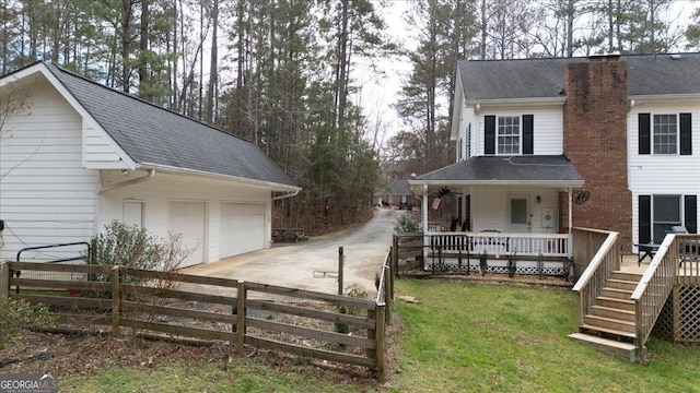 exterior space with driveway, a shingled roof, an attached garage, fence, and a porch