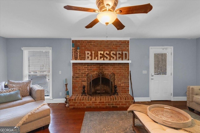 living room featuring dark wood-style floors, a fireplace, baseboards, and a ceiling fan