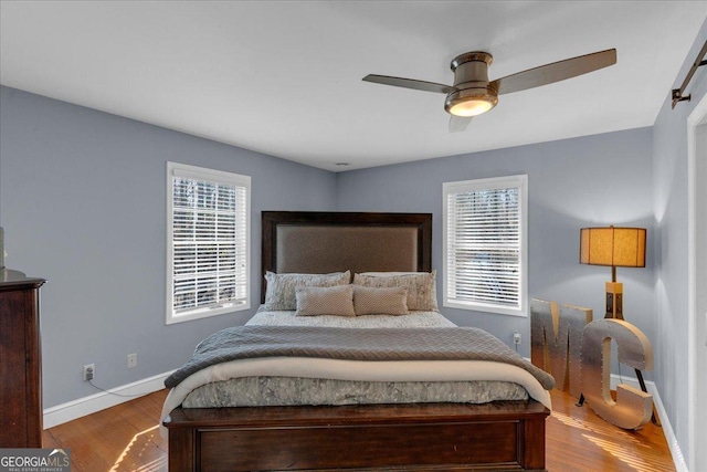 bedroom featuring ceiling fan, baseboards, and wood finished floors