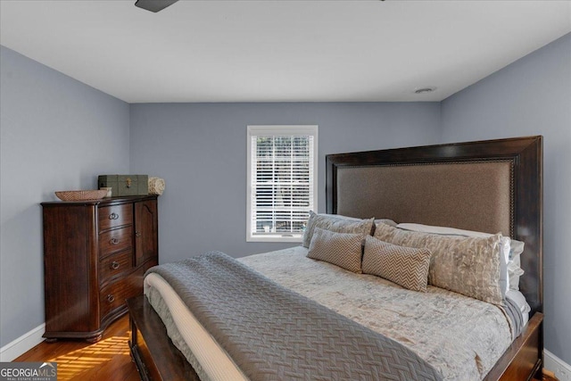 bedroom featuring baseboards and wood finished floors