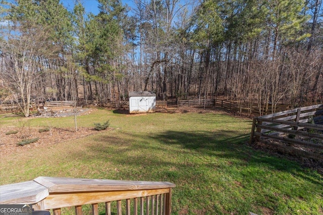 view of yard with an outbuilding, fence, and a storage shed