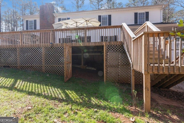 rear view of house with a lawn, a chimney, and a wooden deck