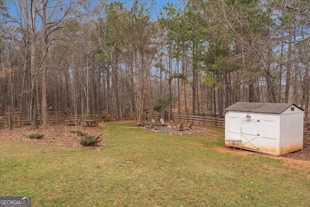 view of yard featuring an outdoor structure, fence, and a shed