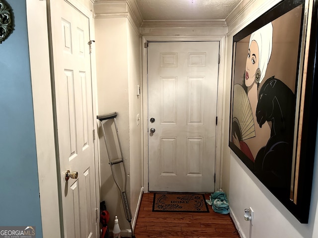 doorway with a textured ceiling, hardwood / wood-style flooring, and crown molding