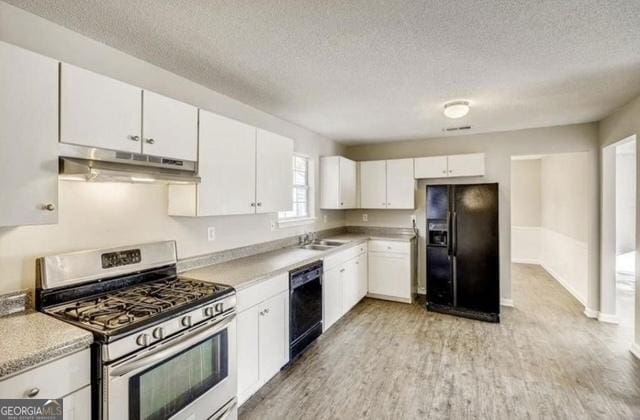 kitchen featuring black appliances, under cabinet range hood, white cabinetry, light wood-style floors, and light countertops