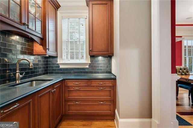 kitchen with decorative backsplash, sink, and light hardwood / wood-style flooring