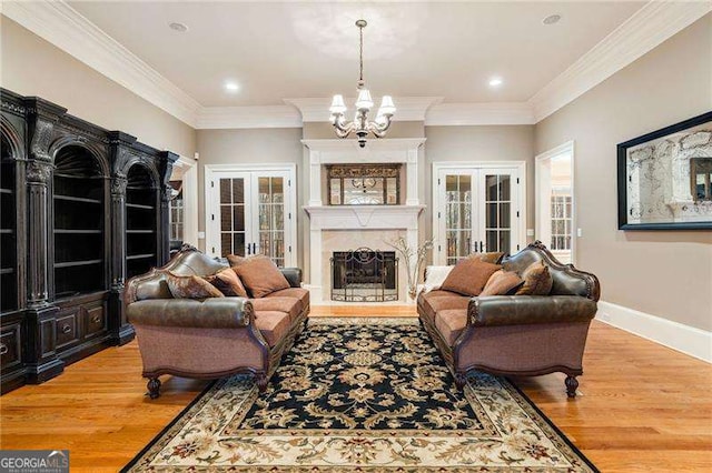 3201 Hobsons Ridge Trl NW, Acworth, GA 30101 - living area featuring a chandelier, light wood-style floors, crown molding, a high end fireplace, and french doors