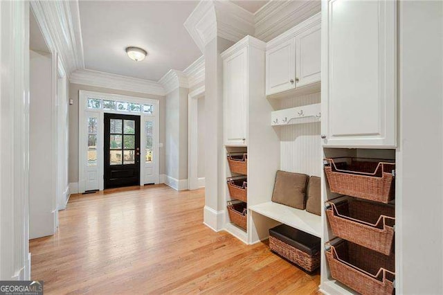 mudroom with ornamental molding and light hardwood / wood-style flooring