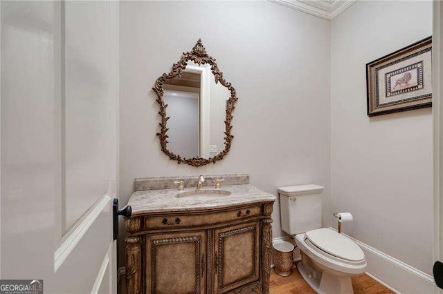 bathroom with toilet, vanity, and wood-type flooring