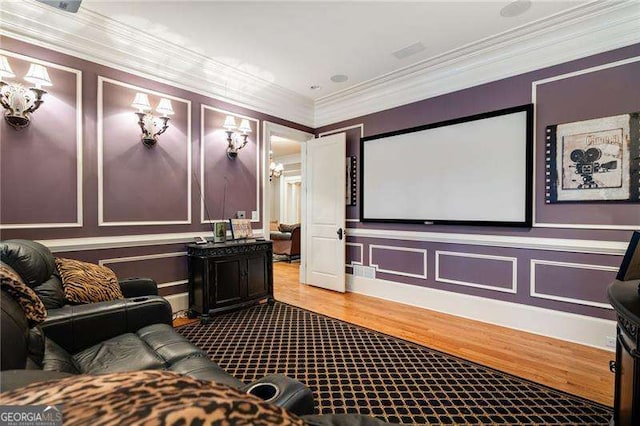 home theater room with crown molding and wood-type flooring