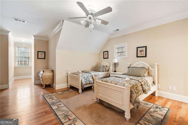 bedroom with ceiling fan, crown molding, multiple windows, and wood-type flooring