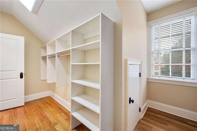 spacious closet featuring hardwood / wood-style floors and vaulted ceiling