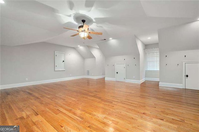 bonus room with light wood-type flooring, vaulted ceiling, electric panel, and ceiling fan