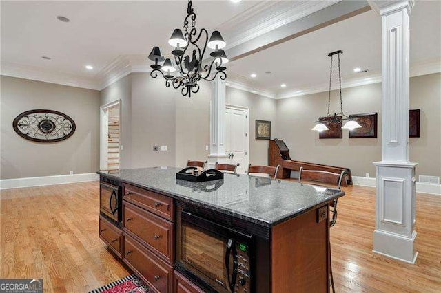3201 Hobsons Ridge Trl NW, Acworth, GA 30101 - kitchen featuring ornate columns, black microwave, ornamental molding, light wood-style flooring, and a kitchen island