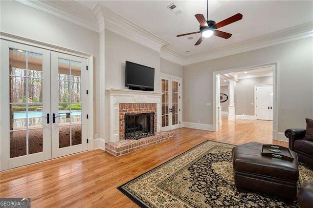 3201 Hobsons Ridge Trl NW, Acworth, GA 30101 - living area with french doors, wood finished floors, a ceiling fan, a fireplace, and ornamental molding