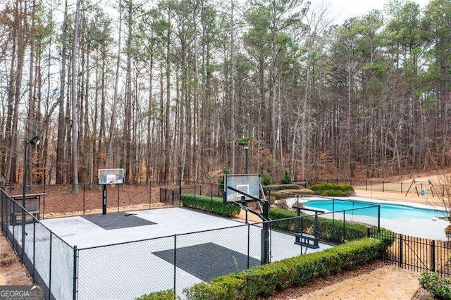 view of sport court with a fenced in pool