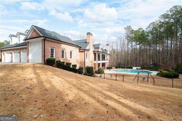 view of home's exterior featuring a garage and a fenced in pool