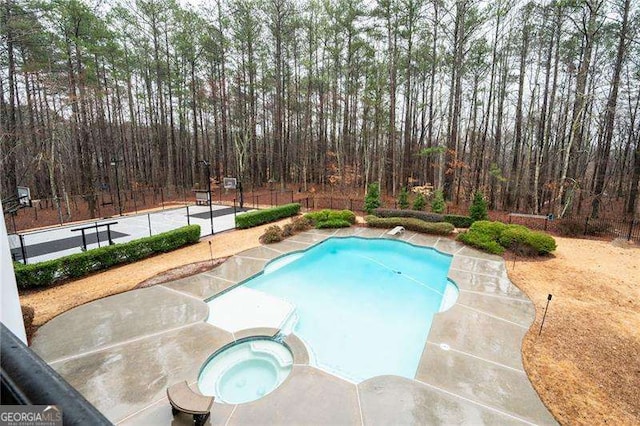 view of swimming pool featuring an in ground hot tub