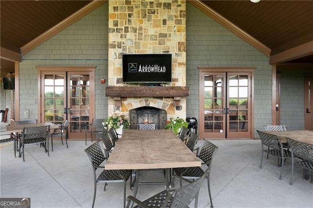 view of patio / terrace with french doors and an outdoor stone fireplace