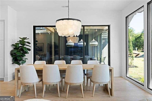 dining room featuring light wood-type flooring and an inviting chandelier