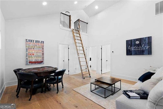 living room with high vaulted ceiling and wood-type flooring