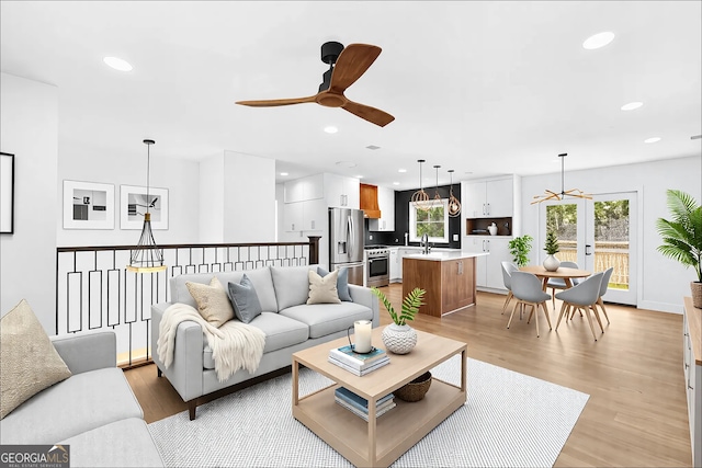 living room featuring a ceiling fan, light wood-type flooring, and recessed lighting