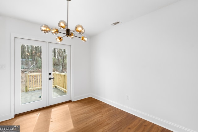 doorway to outside with a chandelier, french doors, visible vents, and wood finished floors