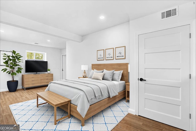 bedroom with recessed lighting, wood finished floors, visible vents, baseboards, and beamed ceiling