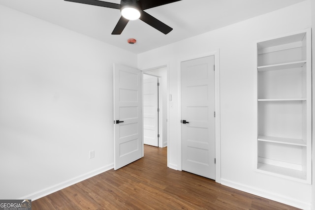 unfurnished bedroom with baseboards, dark wood finished floors, and a ceiling fan