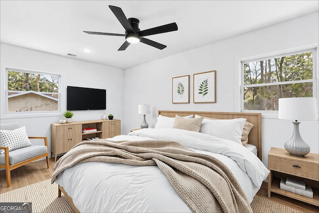 bedroom with a ceiling fan, wood finished floors, visible vents, and recessed lighting