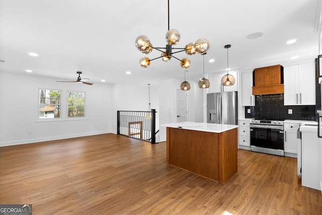 kitchen with a kitchen island, stainless steel appliances, backsplash, and wood finished floors