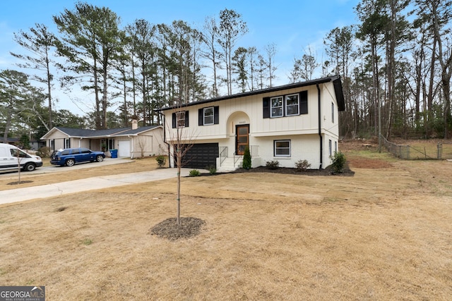 split foyer home featuring concrete driveway and brick siding