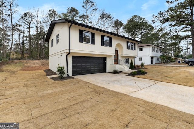 bi-level home with a garage, concrete driveway, and brick siding