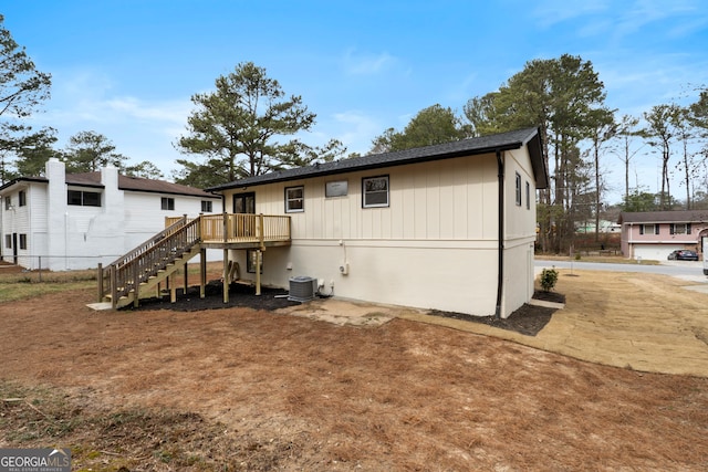 rear view of property featuring stairway, a deck, and central AC