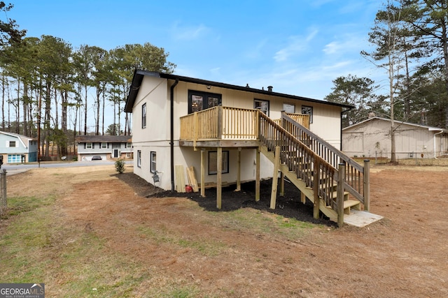 rear view of house with stairs and a wooden deck