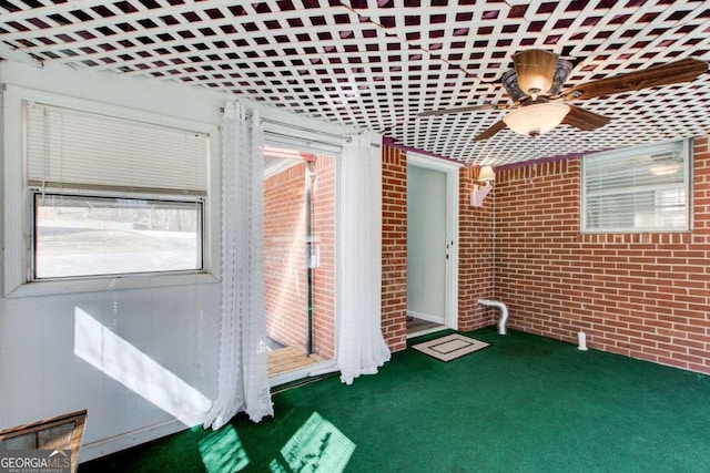 unfurnished sunroom featuring ceiling fan