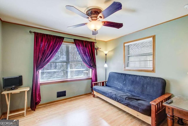 sitting room featuring crown molding, ceiling fan, and wood-type flooring