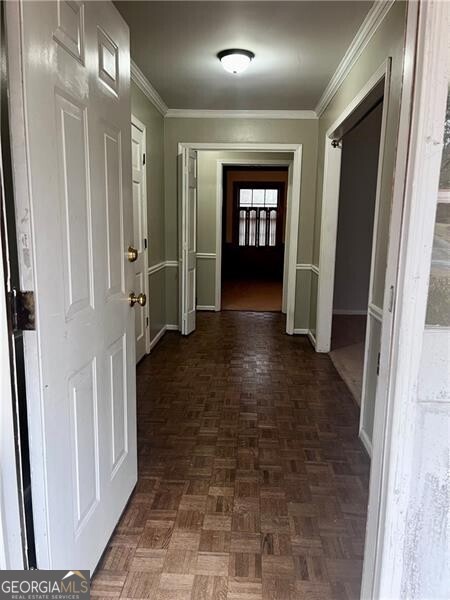 hallway featuring ornamental molding and baseboards