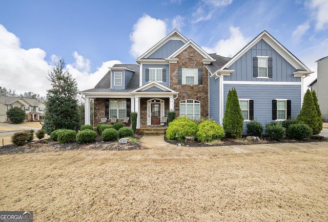 craftsman house featuring covered porch and a front lawn