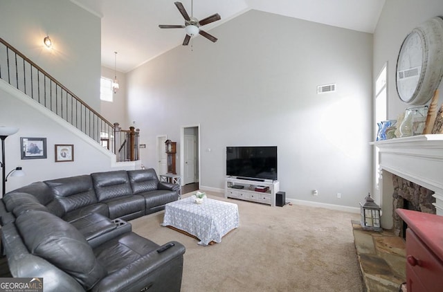 carpeted living room featuring a fireplace, high vaulted ceiling, and ceiling fan with notable chandelier