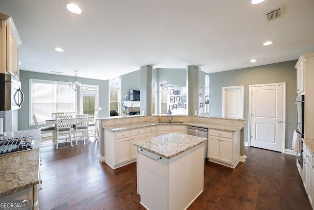 kitchen featuring appliances with stainless steel finishes, sink, a kitchen island, kitchen peninsula, and hanging light fixtures